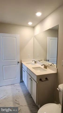 a bathroom with a sink a toilet and mirror