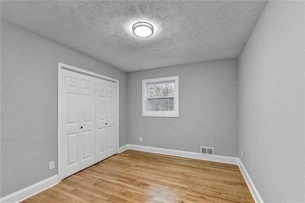 5169 Oxbow Road Stone Mountain, GA 30087 - Photo 26 of 58 an empty room with wooden floor and windows