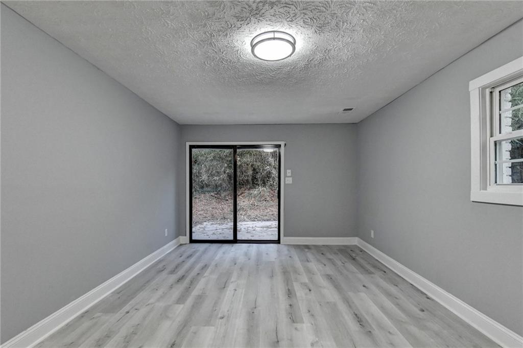 5169 Oxbow Road Stone Mountain, GA 30087 - Photo 46 of 58 an empty room with wooden floor and windows