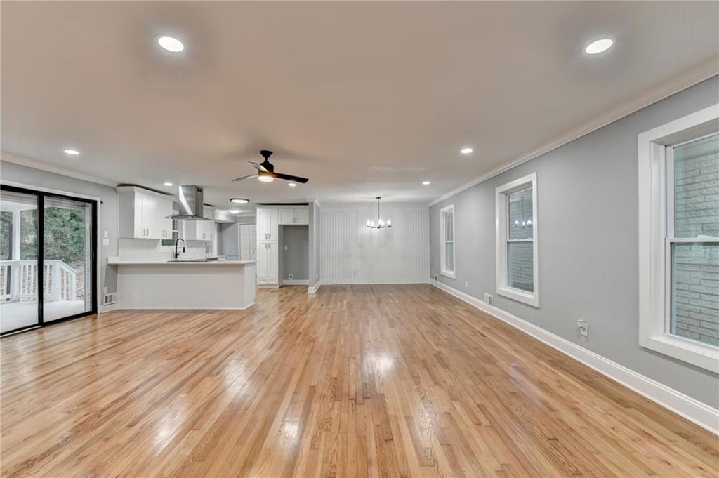 5169 Oxbow Road Stone Mountain, GA 30087 - Photo 6 of 58 a view of kitchen and empty room with wooden floor and windows