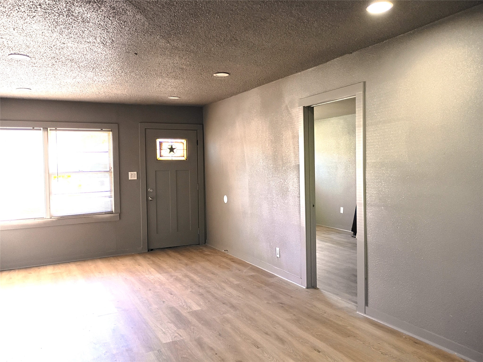 5617 Malmedy Road Houston, TX 77033 - Photo 3 of 12 an empty room with wooden floor and windows