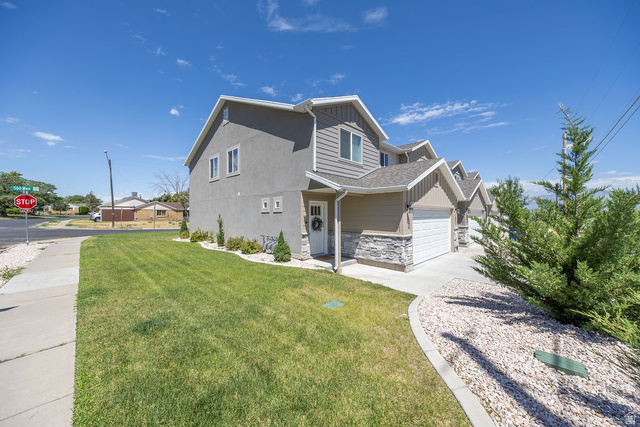 4991 South 475 West Washington Terrace, UT 84405 - Photo 31 of 31 Multi-level property featuring a stucco and siding exterior, an attached garage, a manicured lawn, and a decorative stone landscaping bed!!!