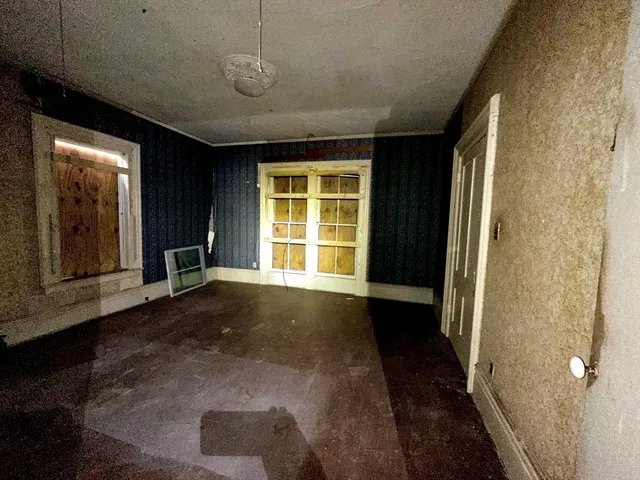 a view of a hallway with wooden floor and a window