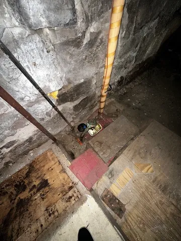 a view of a house with a yard fire pit and a large tree
