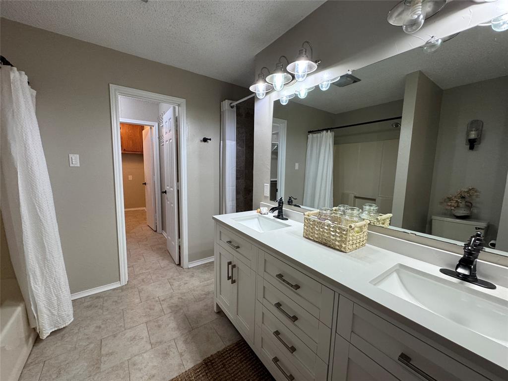 2202 Carriage Estates Road Sherman, TX 75092 - Photo 11 of 18 a bathroom with a double vanity sink and a mirror