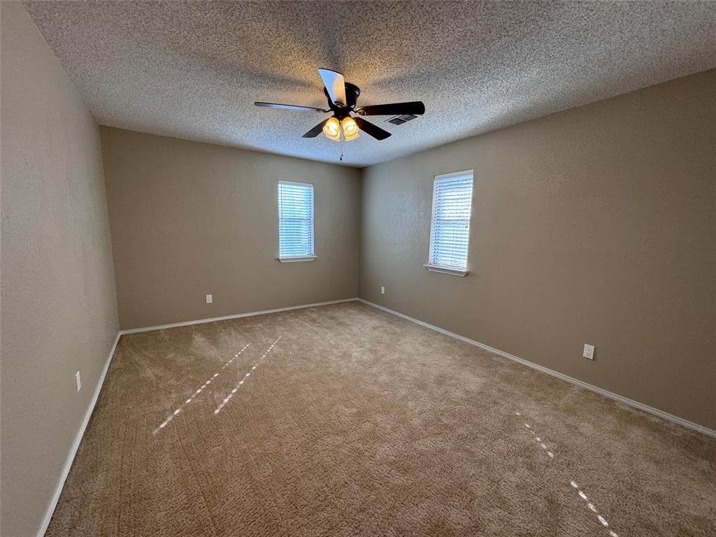2202 Carriage Estates Road Sherman, TX 75092 - Photo 15 of 18 an empty room with windows and fan