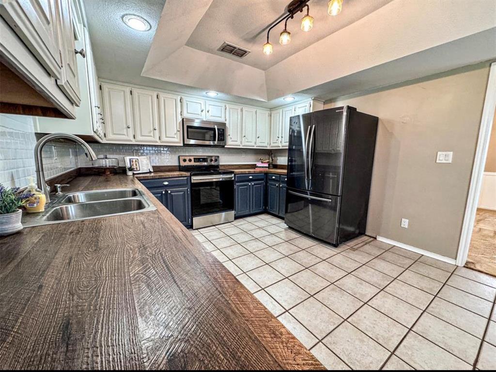 2202 Carriage Estates Road Sherman, TX 75092 - Photo 5 of 18 a kitchen with stainless steel appliances granite countertop a refrigerator a stove top oven a sink and dishwasher