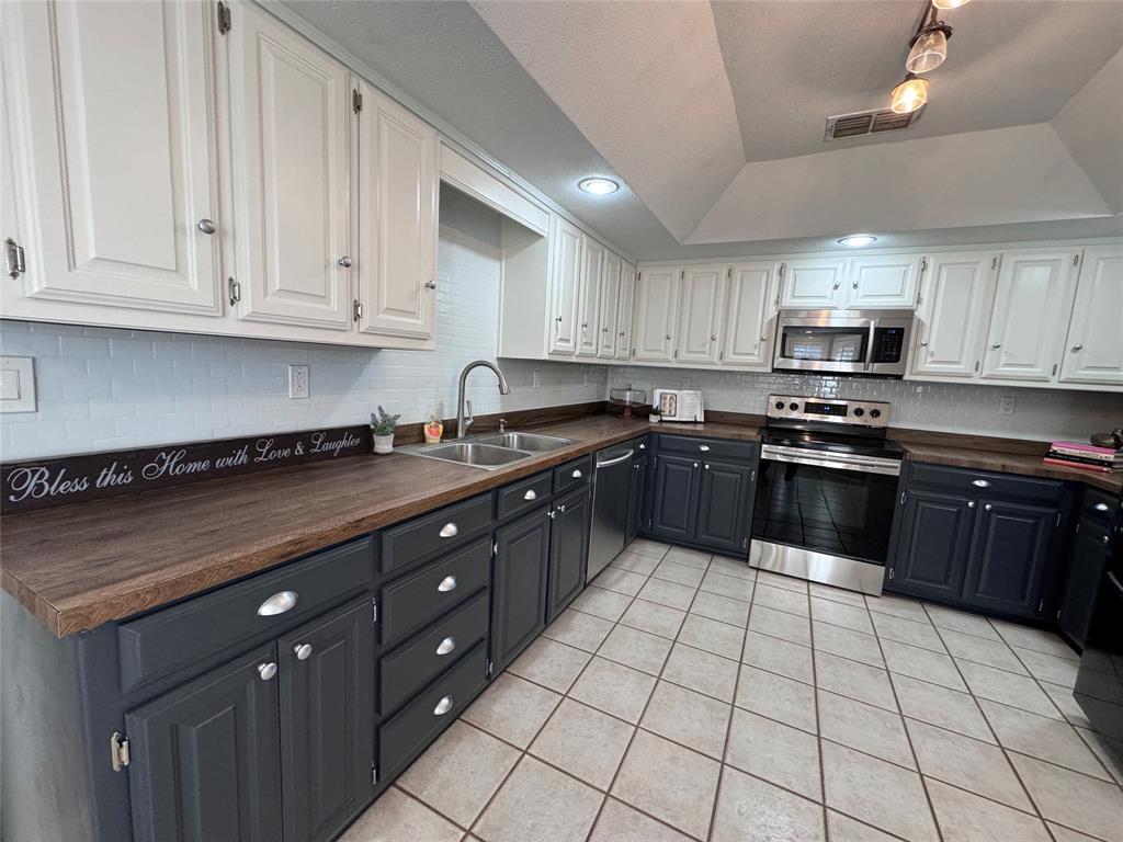 2202 Carriage Estates Road Sherman, TX 75092 - Photo 7 of 18 a kitchen with stainless steel appliances granite countertop a stove a sink dishwasher a refrigerator and a oven