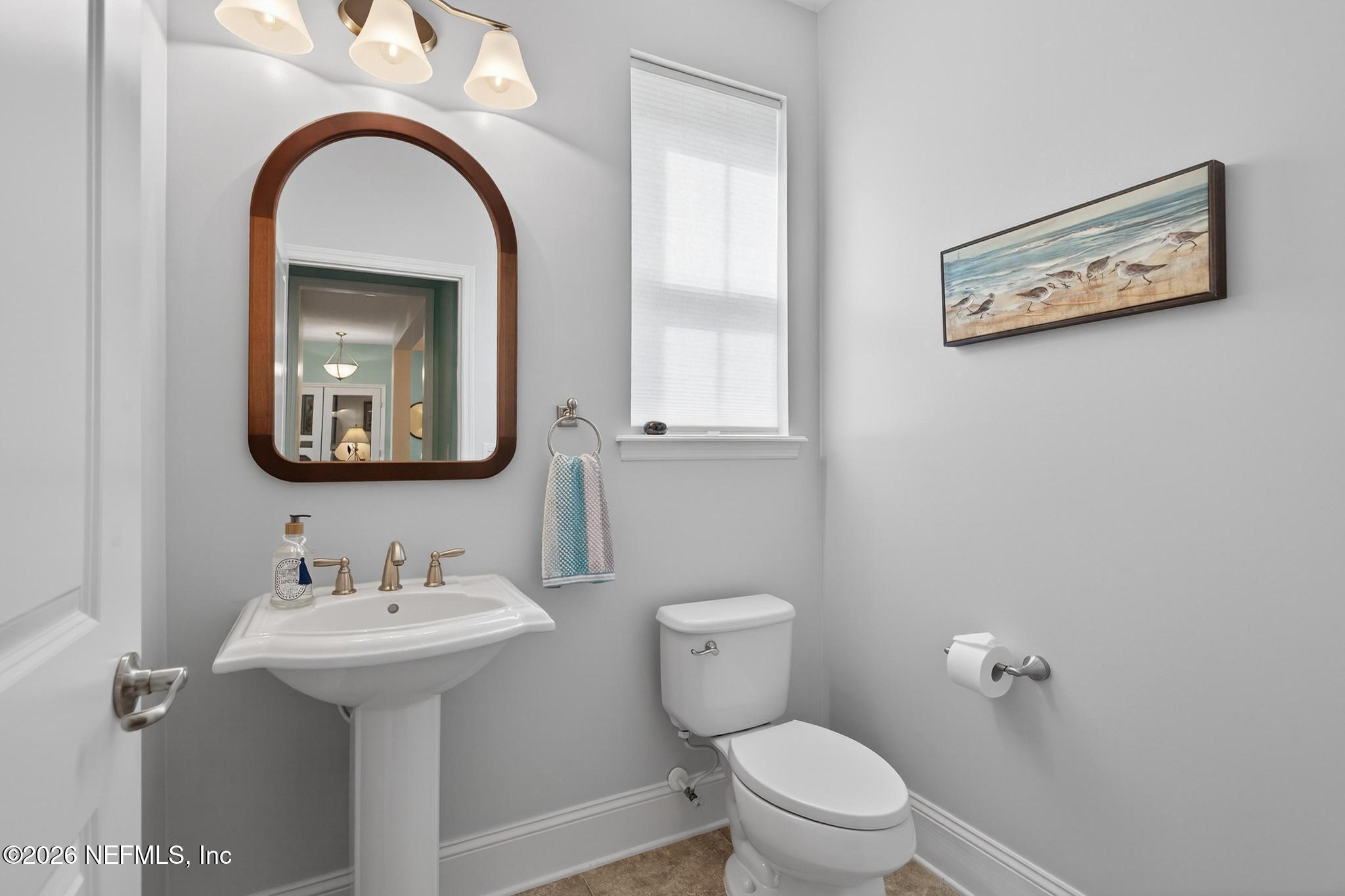 1906 North Loop Parkway St. Augustine, FL 32095 - Photo 15 of 87 a bathroom with a toilet sink and mirror