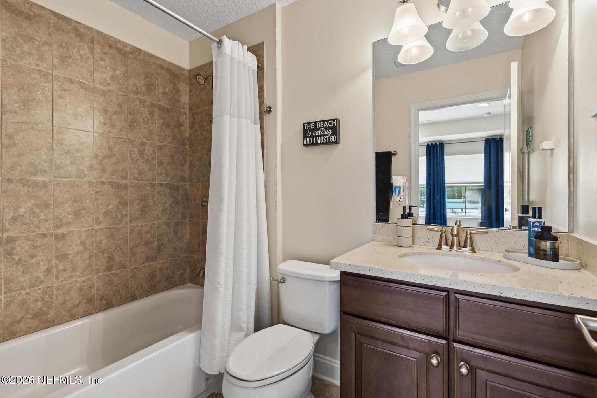 1906 North Loop Parkway St. Augustine, FL 32095 - Photo 17 of 87 a bathroom with a sink a toilet a mirror a bathtub and shower