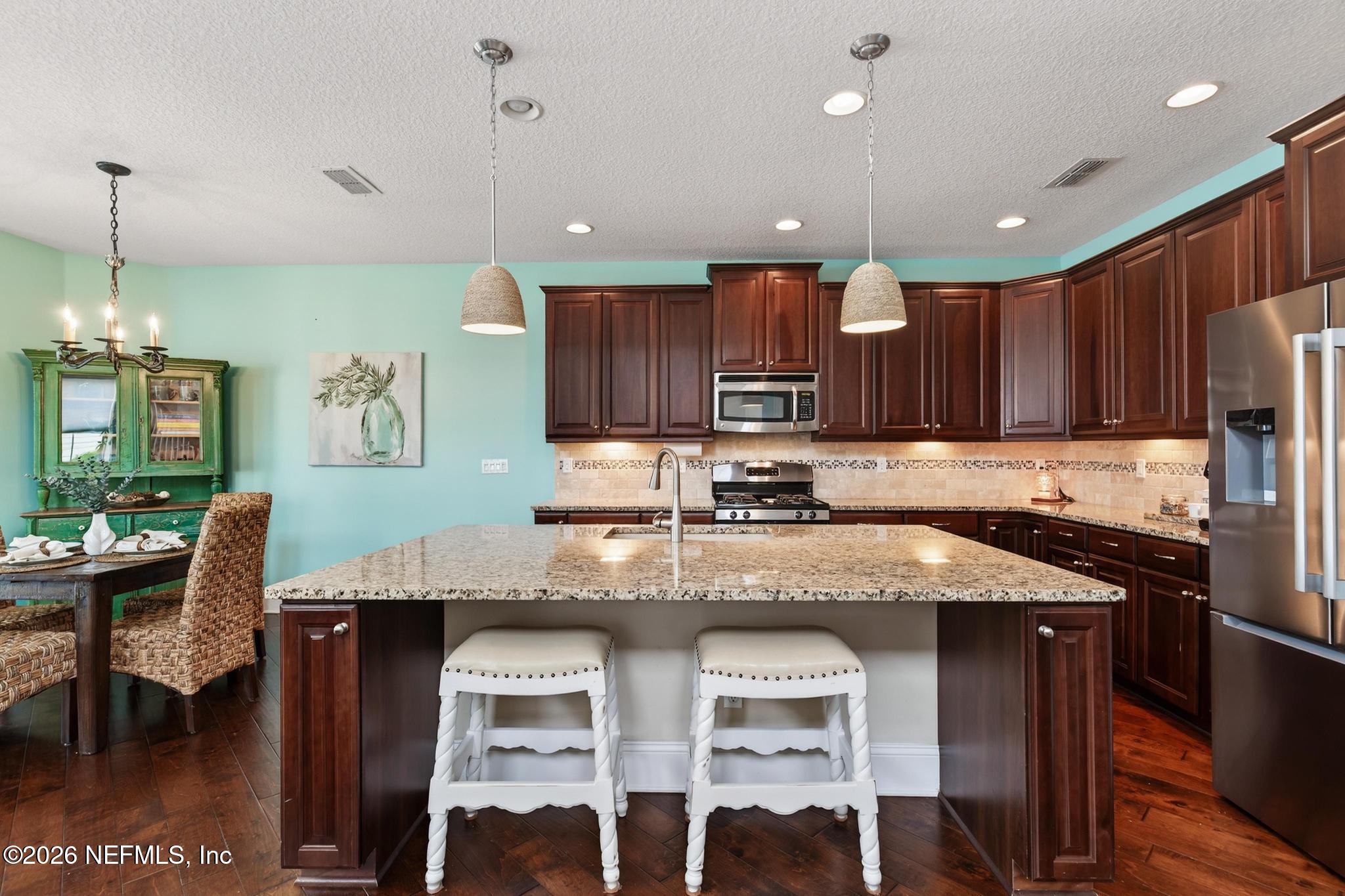 1906 North Loop Parkway St. Augustine, FL 32095 - Photo 22 of 87 a kitchen with stainless steel appliances granite countertop wooden cabinets a stove a sink and a refrigerator