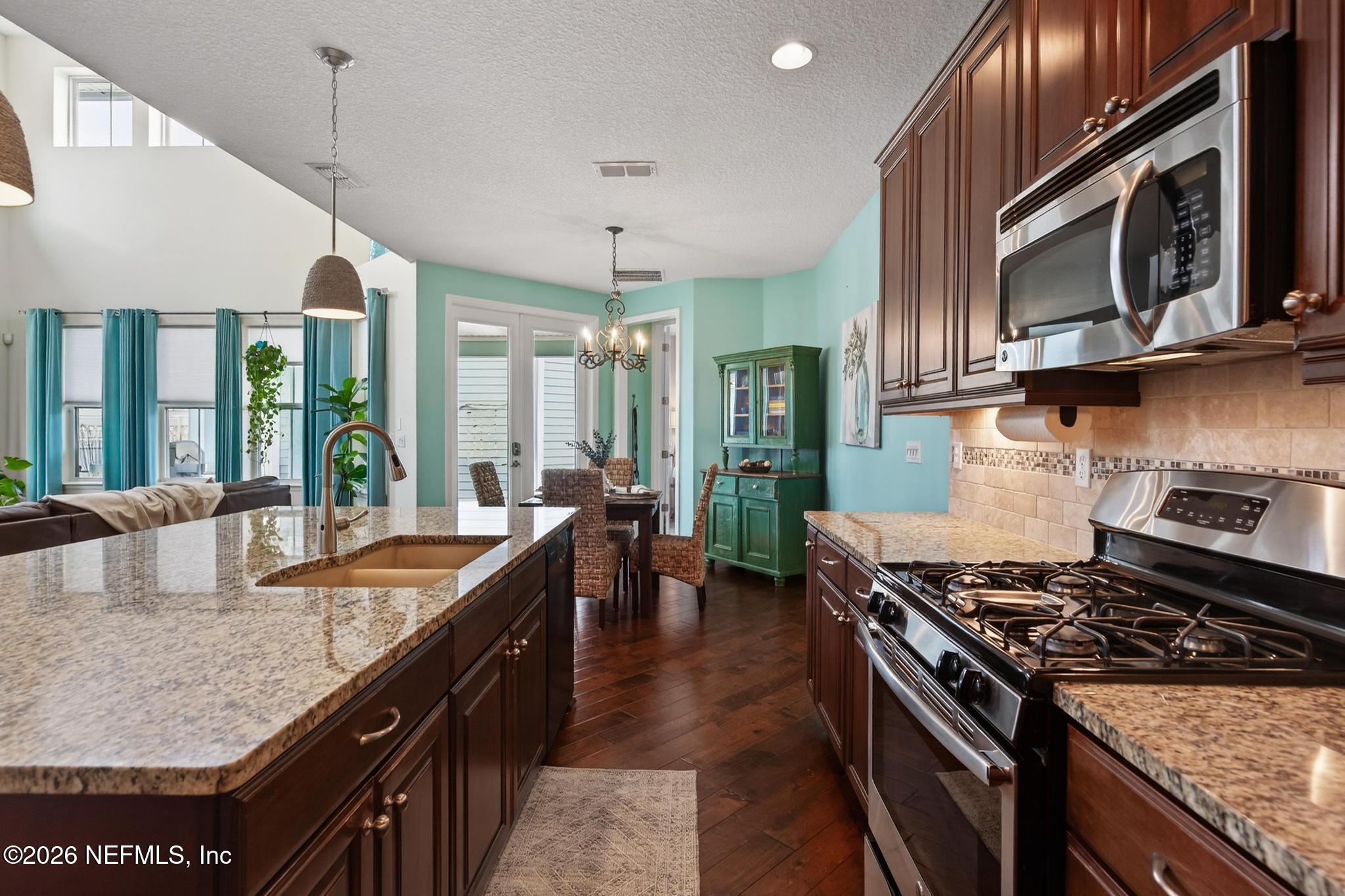 1906 North Loop Parkway St. Augustine, FL 32095 - Photo 23 of 87 a kitchen with stainless steel appliances granite countertop a stove a sink and a microwave