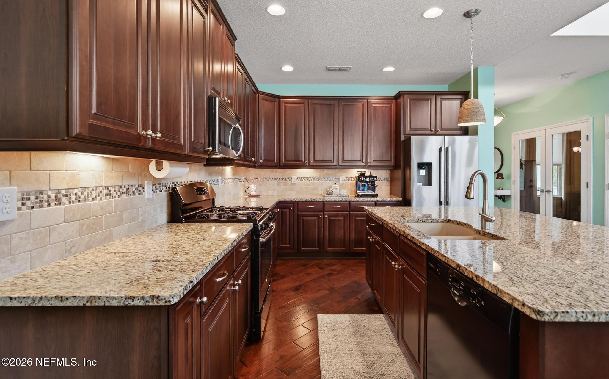 1906 North Loop Parkway St. Augustine, FL 32095 - Photo 25 of 87 a kitchen with granite countertop kitchen island stainless steel appliances a sink stove top oven and cabinets