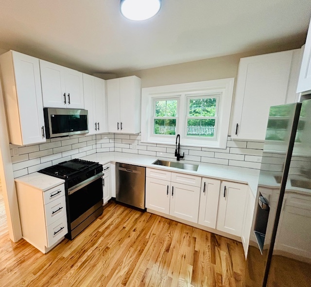 200 South Delaplaine Road Riverside, IL 60546 - Photo 9 of 21 a kitchen with granite countertop a sink a stove a microwave and wooden cabinets