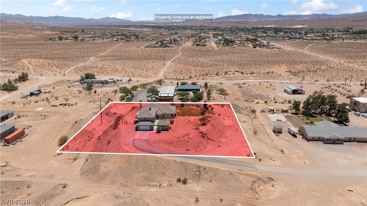 575 Gann Avenue Logandale, NV 89021 - Photo 70 of 75 An aerial perspective reveals a private residence nestled amidst a vast desert landscape with distant mountain views.