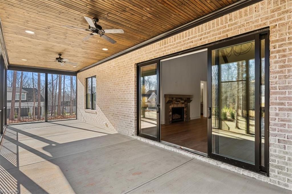 7999 Cokely Court Oak Ridge, NC 27310 - Photo 5 of 49 collapsible doors to covered porch with ceiling fan