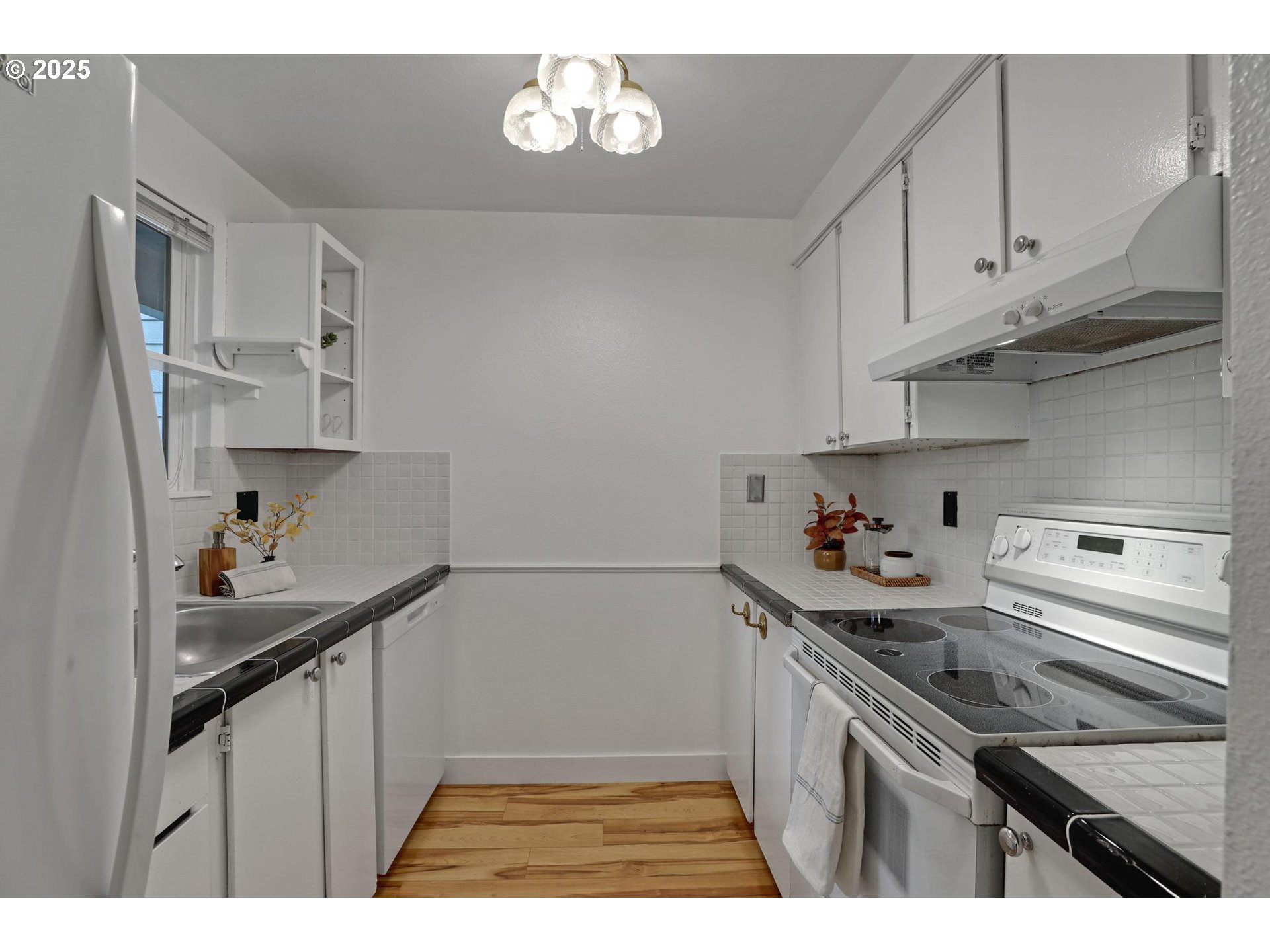 5488 Southwest Alger Avenue, Unit I7 Beaverton, OR 97005 - Photo 7 of 16 a kitchen with stainless steel appliances a sink stove and cabinets