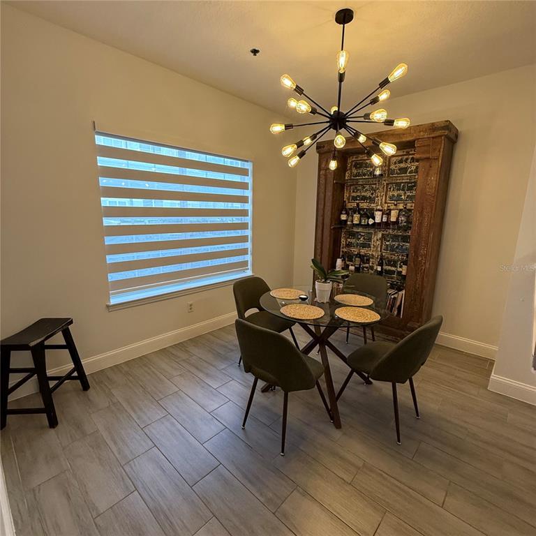 4833 Cypress Woods Drive, Unit 4112 Orlando, FL 32811 - Photo 2 of 10 a dining room with furniture and wooden floor
