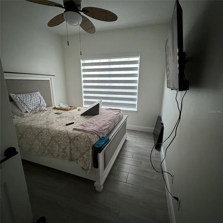 4833 Cypress Woods Drive, Unit 4112 Orlando, FL 32811 - Photo 9 of 10 a bedroom with a bed and a chandelier