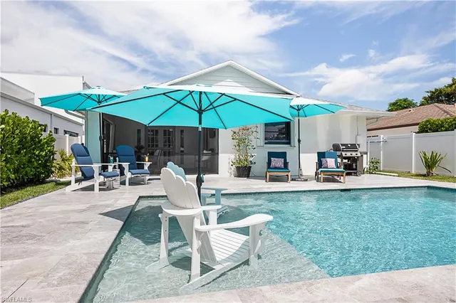 a view of a patio with chairs and table under an umbrella