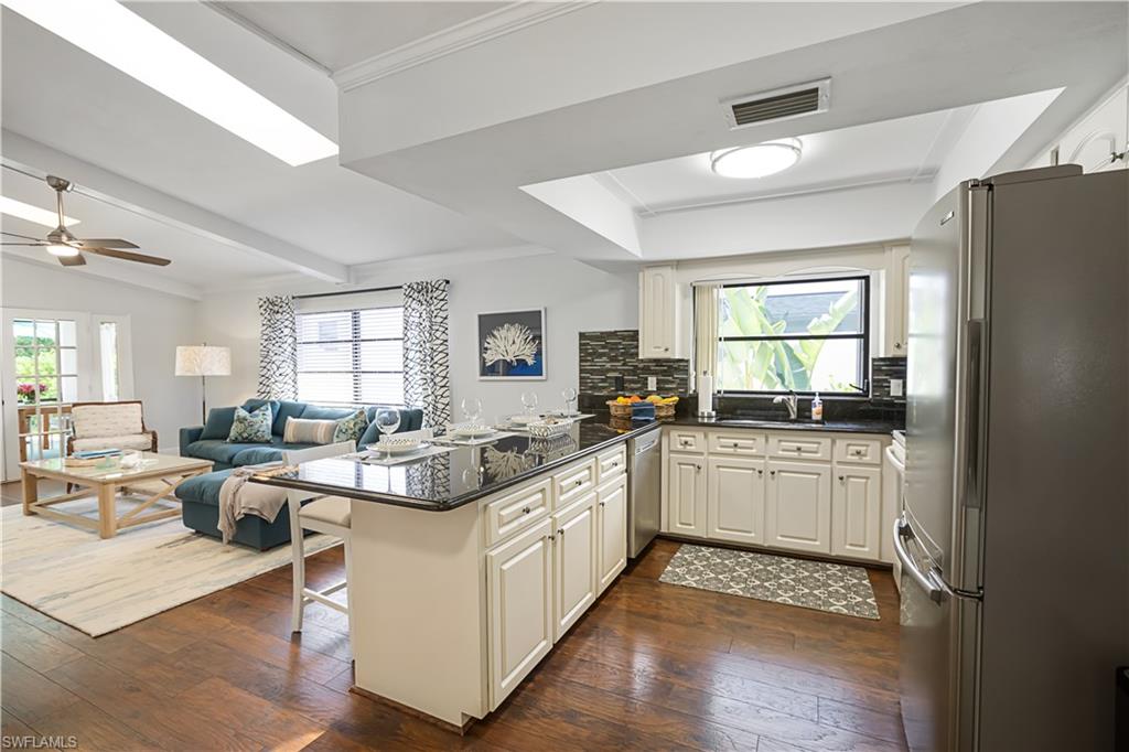 682 95th Avenue North Naples, FL 34108 - Photo 30 of 30 a large white open kitchen with kitchen island a stove a sink a dining table and chairs