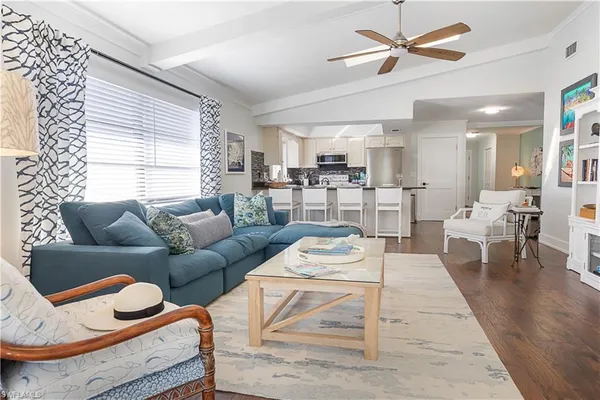 a living room with furniture a rug and kitchen view