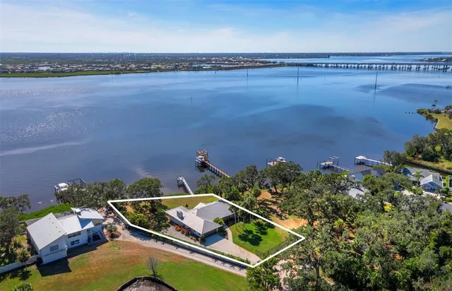 an aerial view of a house with a yard and lake view