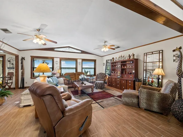 a living room with furniture kitchen view and a window
