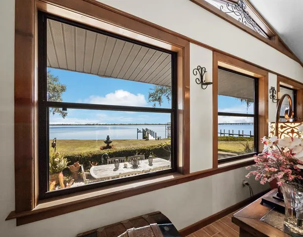 a living room with furniture a flat screen tv and a floor to ceiling window