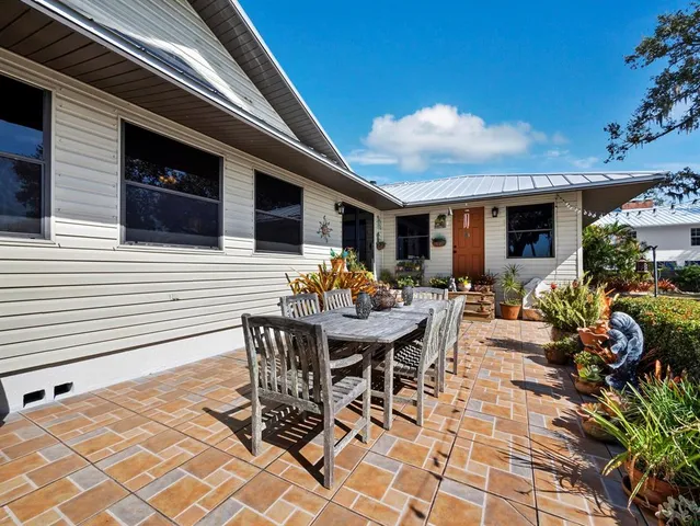 a living room with lots of furniture wooden floor and a large window