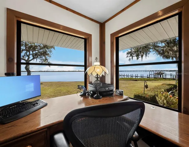 a living room with furniture and a large window with wooden floor