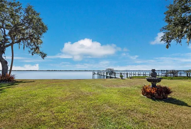 an aerial view of a house with a yard and lake view
