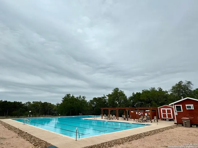a view of a big house with a big yard and large trees