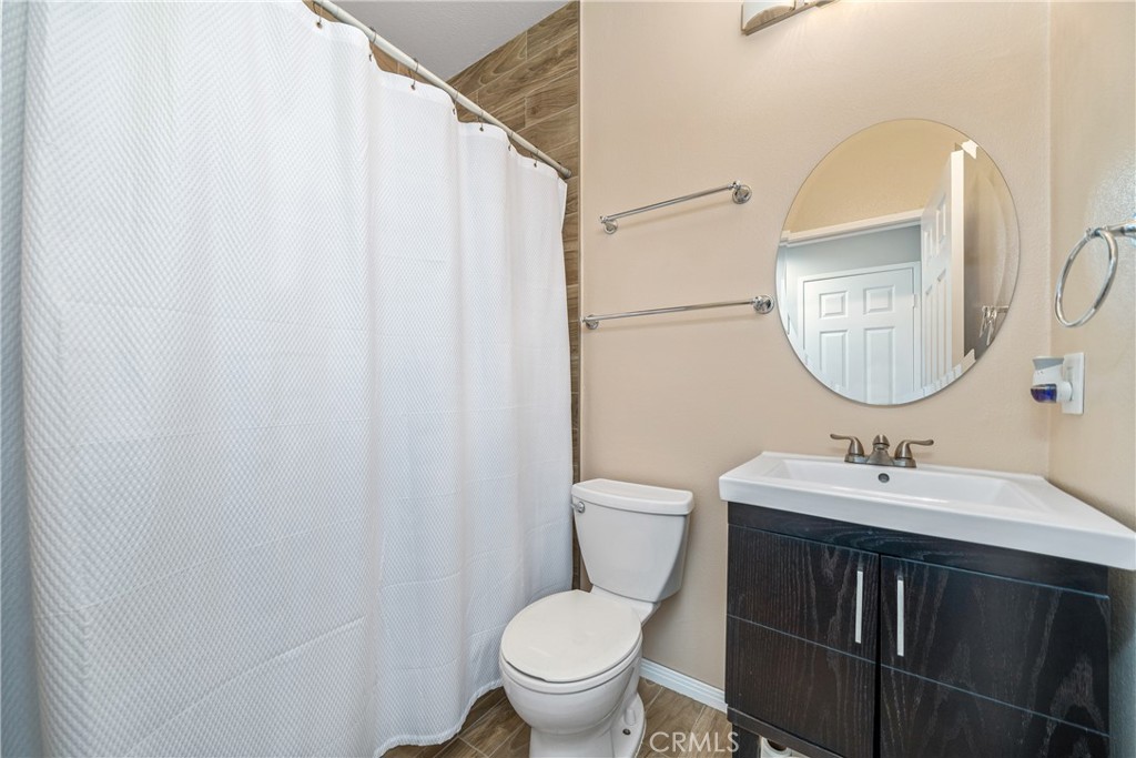 11141 Gardenhurst Court Riverside, CA 92505 - Photo 19 of 65 a bathroom with a toilet sink and mirror