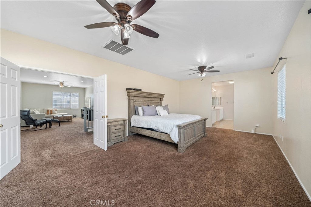11141 Gardenhurst Court Riverside, CA 92505 - Photo 29 of 65 a spacious bedroom with a bed and ceiling fan