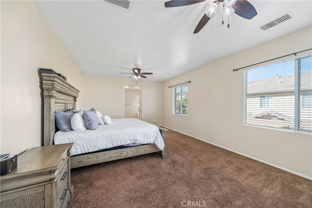 11141 Gardenhurst Court Riverside, CA 92505 - Photo 34 of 65 a bedroom with a large bed chandelier and a window