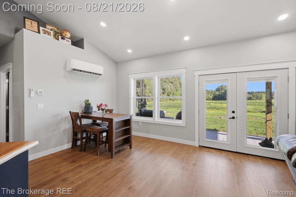9161 East Coldwater Road Davison, MI 48423 - Photo 15 of 52 Vaulted ceiling with recessed lighting, wood-finish flooring, white double doors with glass panels, white-framed windows, and a wall-mounted climate control unit