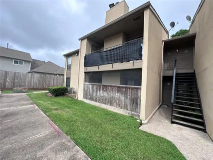 a view of a house with a small yard and wooden fence