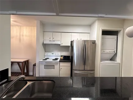 a kitchen with a refrigerator a stove a sink and a cabinets