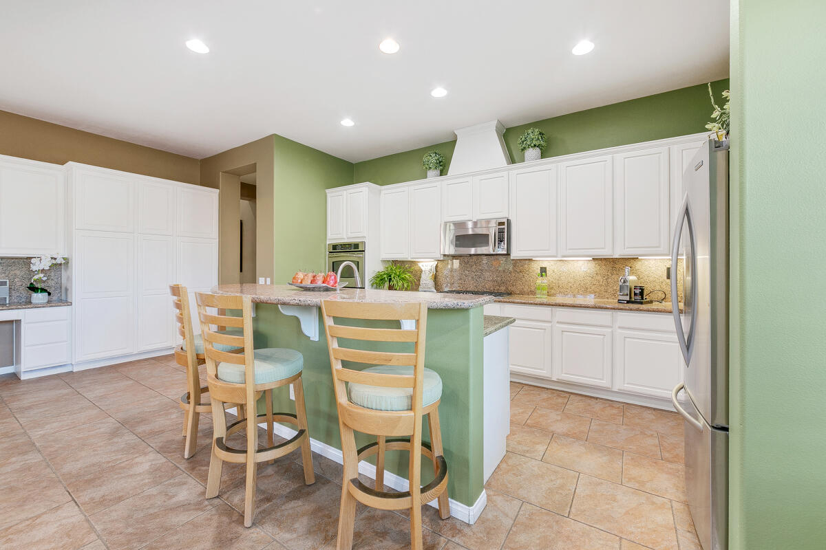 49130 Escalante Street Indio, CA 92201 - Photo 19 of 99 a kitchen with a dining table chairs and white cabinets
