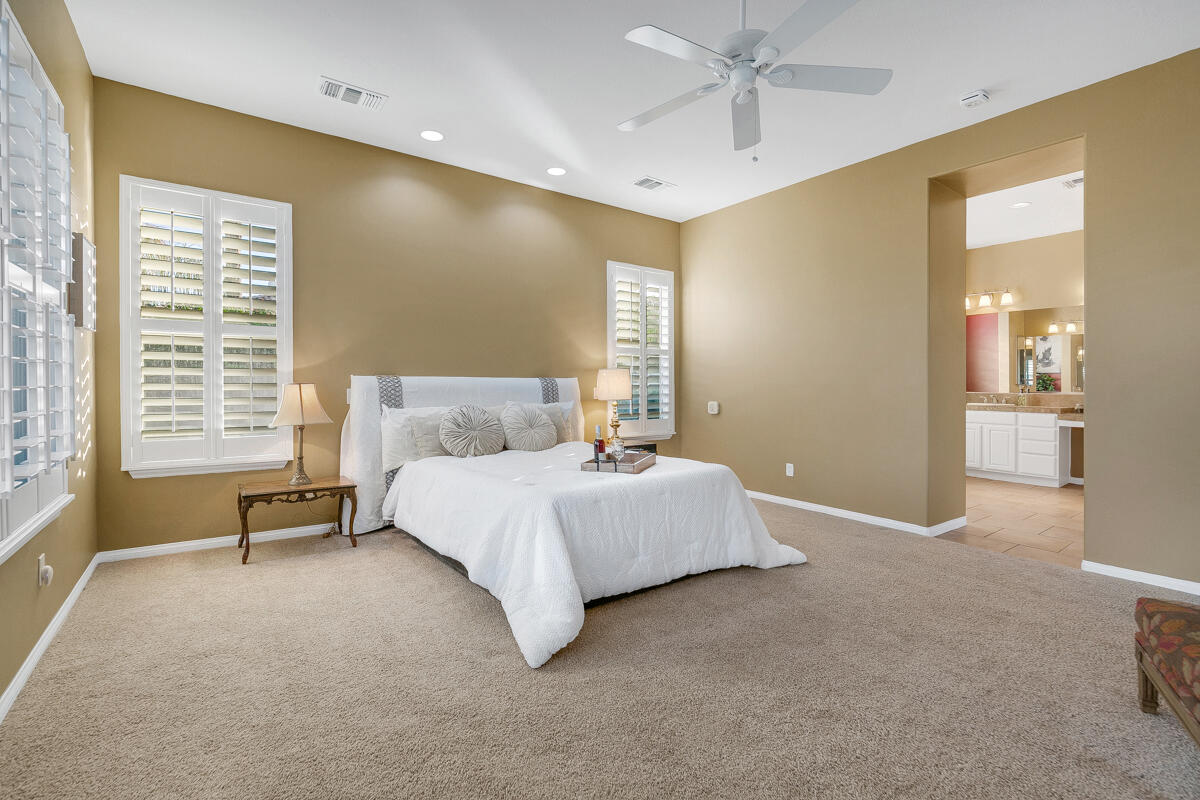 49130 Escalante Street Indio, CA 92201 - Photo 30 of 99 a spacious bedroom with a bed and ceiling fan