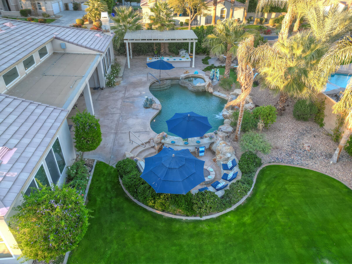 49130 Escalante Street Indio, CA 92201 - Photo 88 of 99 a view of a backyard with table and chairs potted plants and large tree