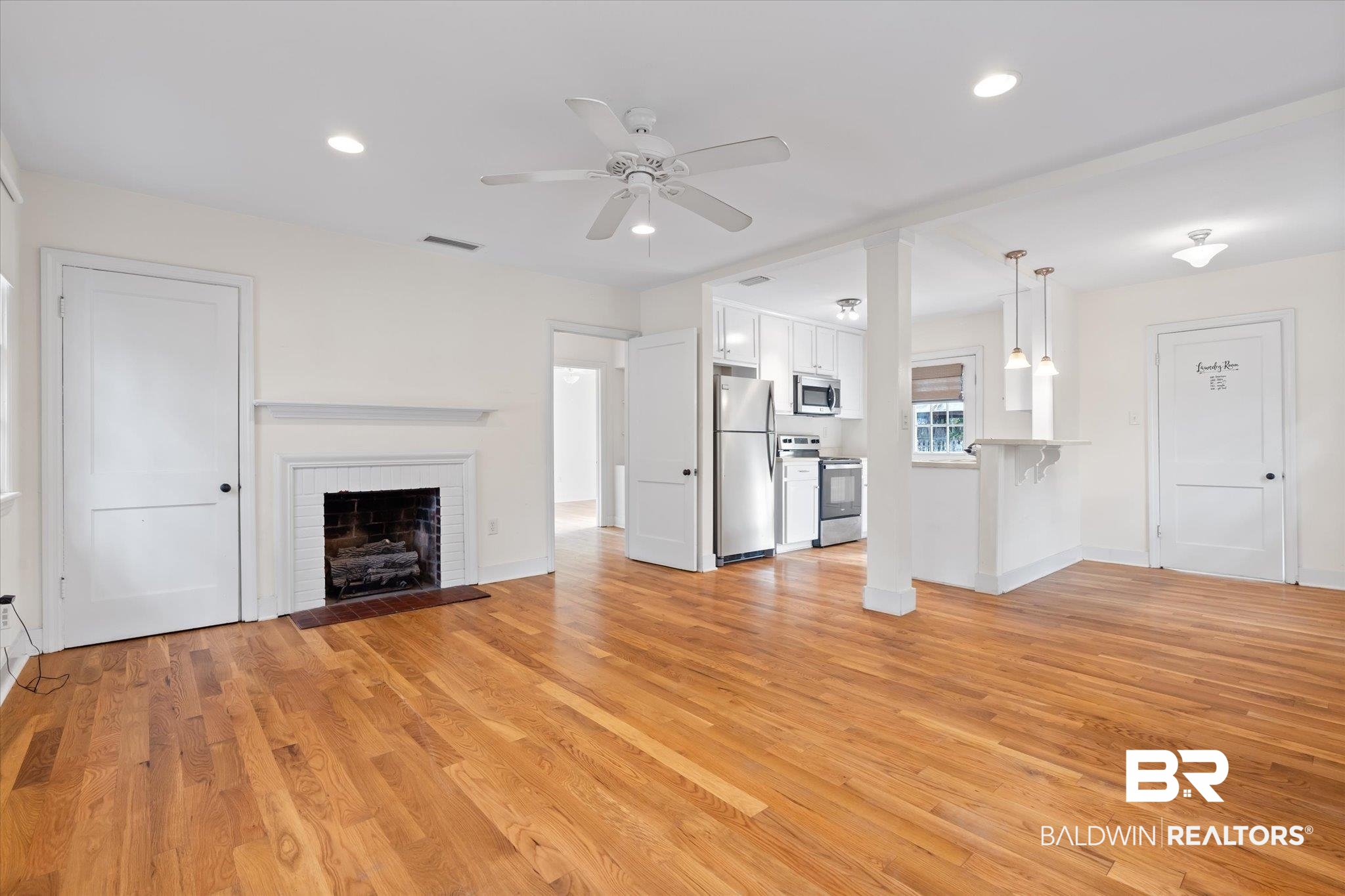 5113 Norton Lane Mobile, AL 36608 - Photo 2 of 20 Unfurnished living room with ceiling fan, a fireplace, and light hardwood / wood-style flooring