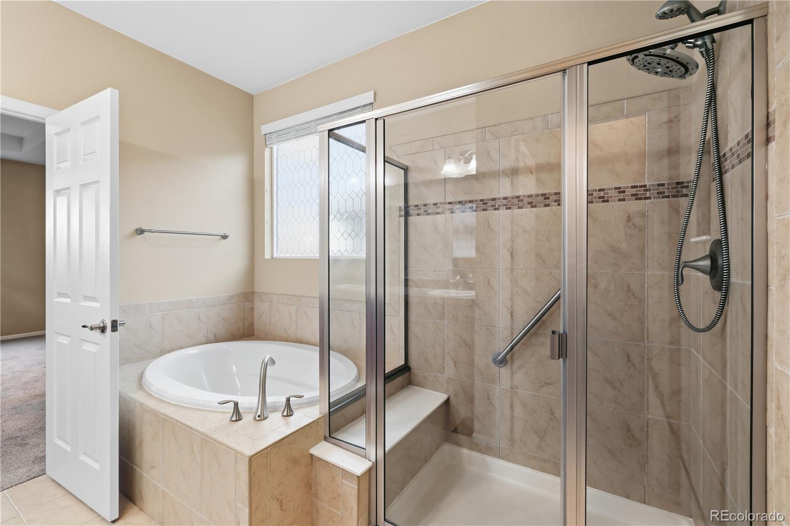 3932 Desert Ridge Circle Castle Rock, CO 80108 - Photo 18 of 49 a bathroom with a glass shower door