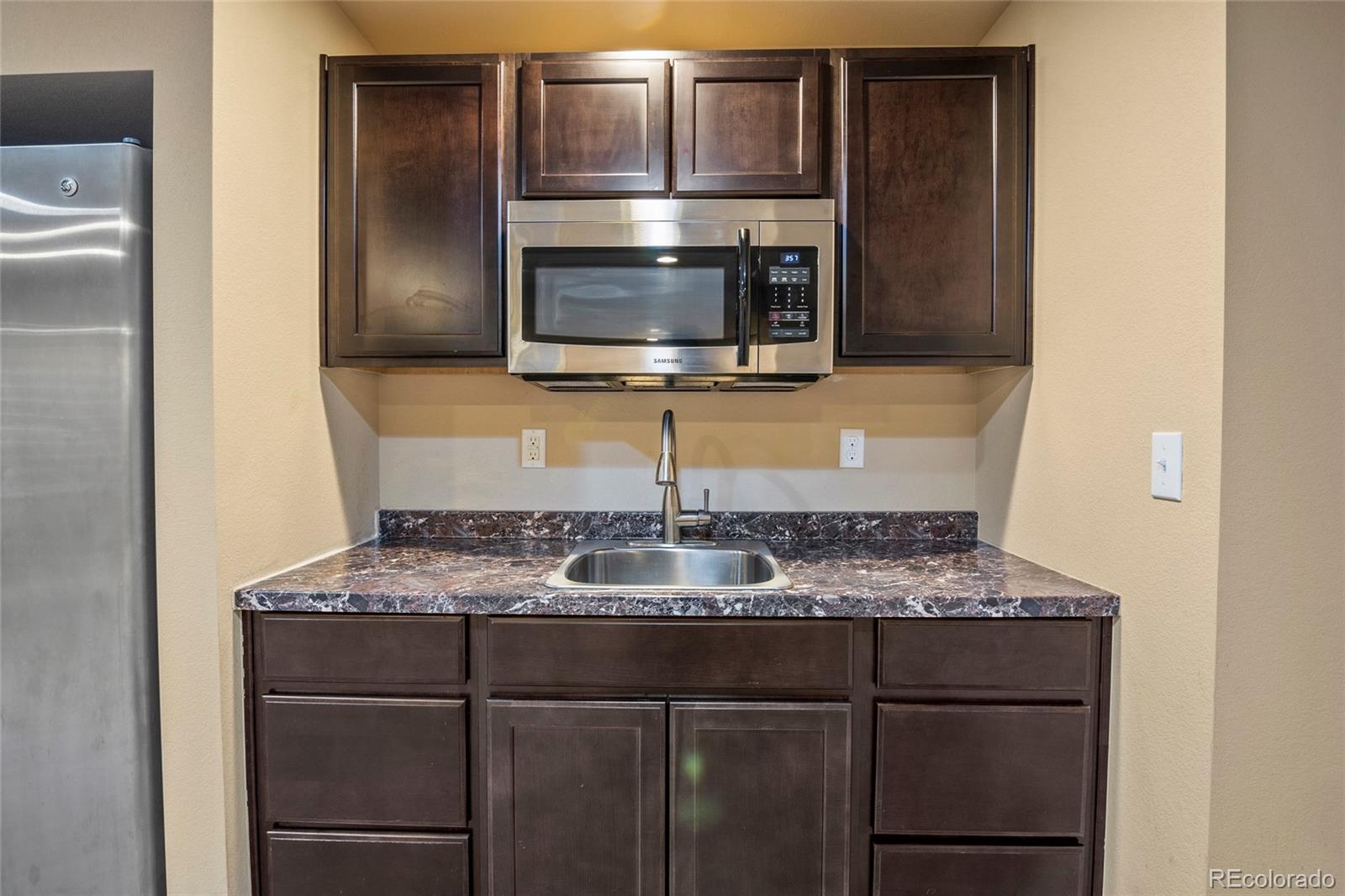 3932 Desert Ridge Circle Castle Rock, CO 80108 - Photo 41 of 49 a kitchen with a sink and a microwave