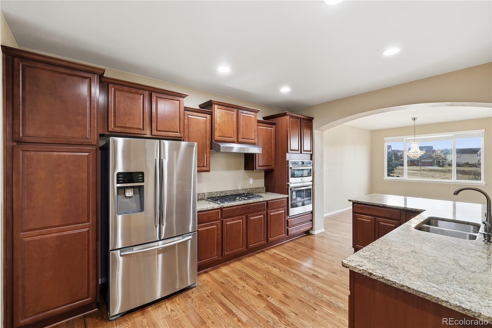 3932 Desert Ridge Circle Castle Rock, CO 80108 - Photo 9 of 49 a kitchen with granite countertop stainless steel appliances a refrigerator stove top oven and sink