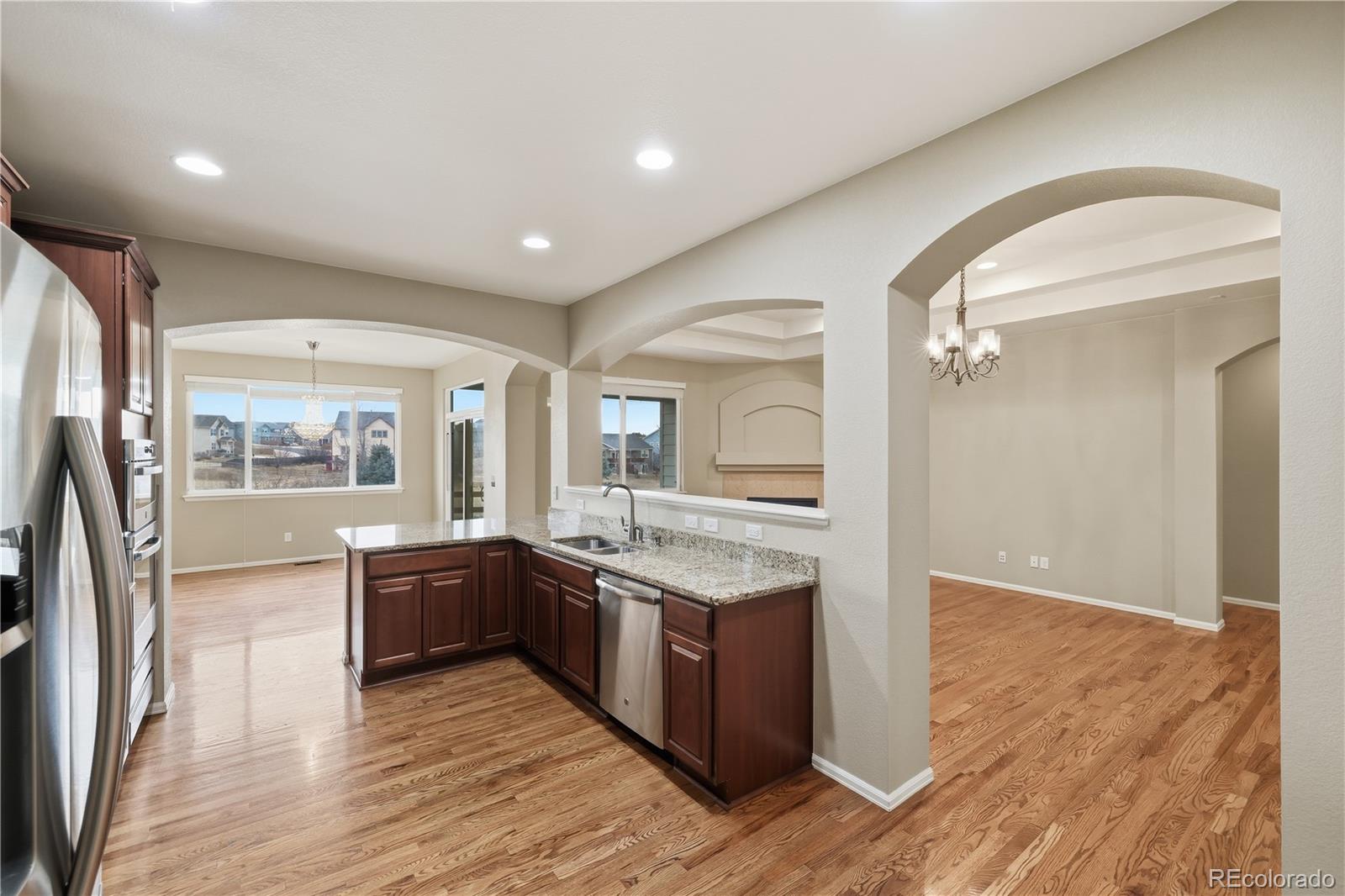 3932 Desert Ridge Circle Castle Rock, CO 80108 - Photo 10 of 49 a large kitchen with stainless steel appliances granite countertop a lot of counter space and wooden floors