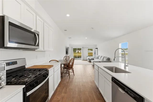 a kitchen with counter top space a sink and appliances