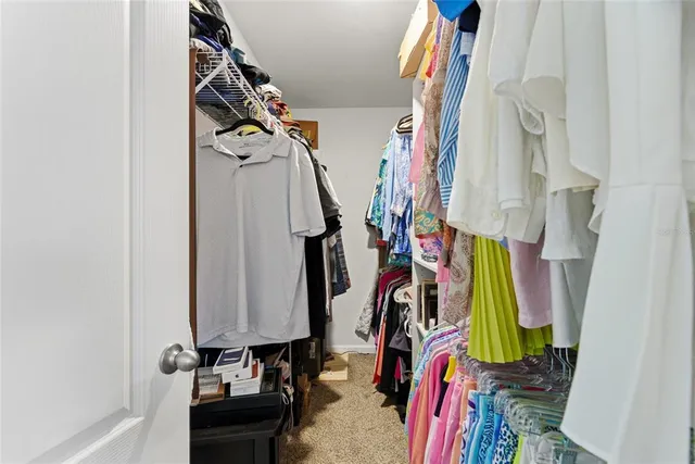 a view of walk in closet with clothes