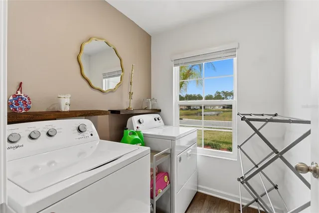 a utility room with dryer washer and a view of living room